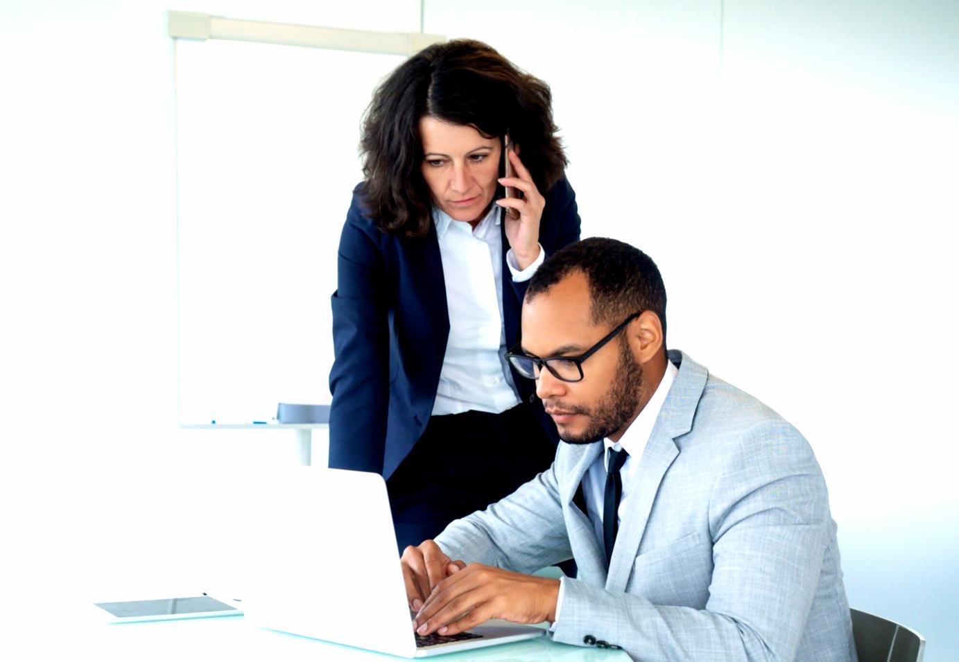 Business professional reviewing financial documents and analytics on computer screen